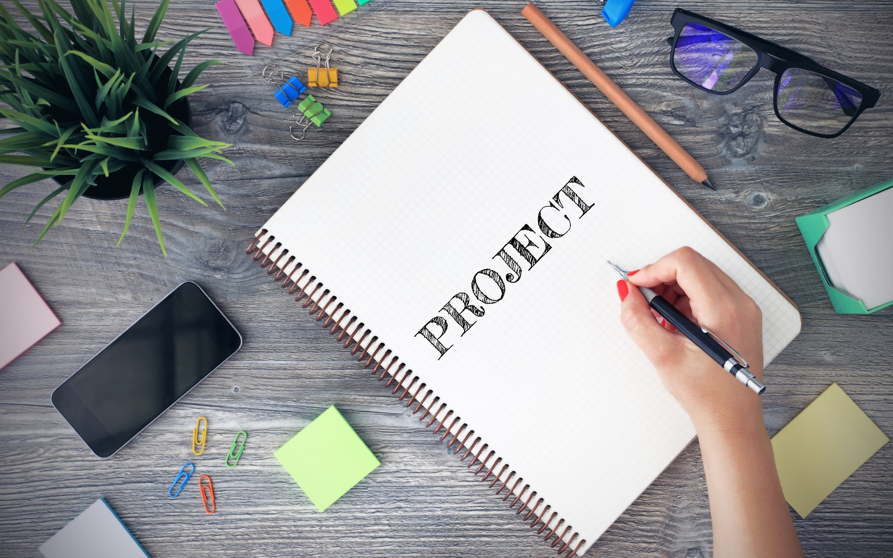A project notebook on a desk with colorful study supplies